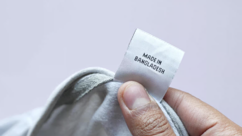 Tailor guiding cotton through a sewing machine